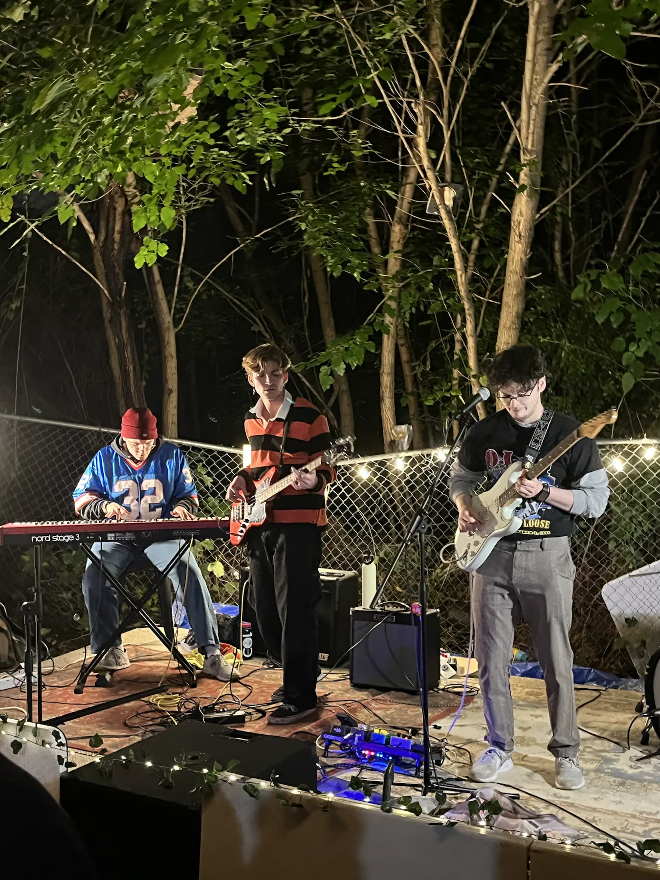 Jack Hansen playing keyboard with a band at an outdoor night show