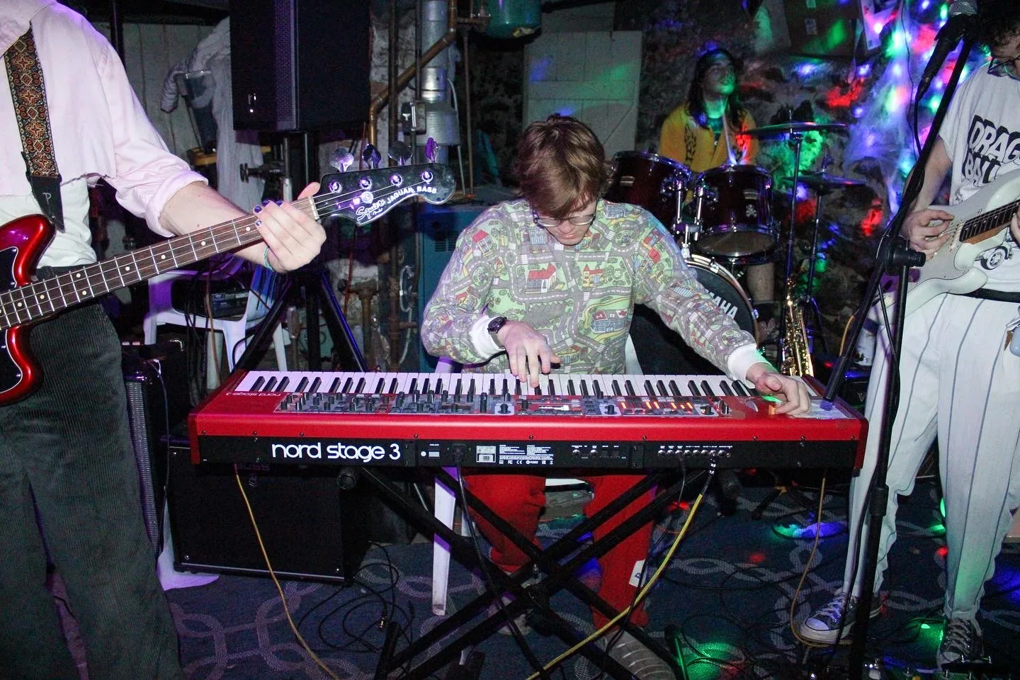 Jack Hansen playing a red keyboard with a live band